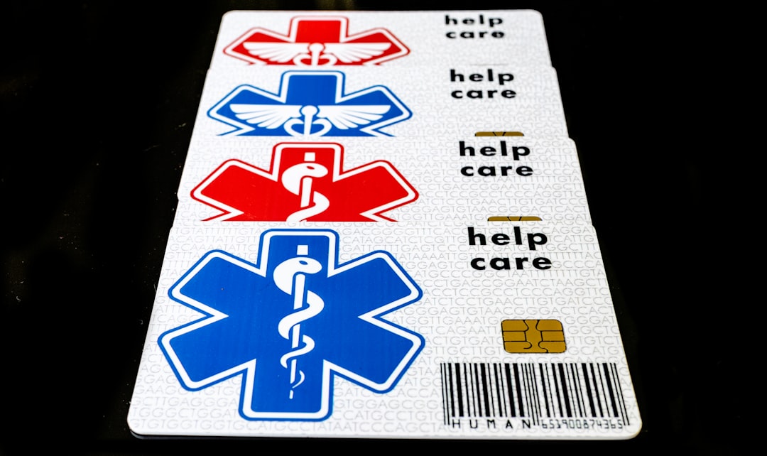 "Stack of medical identification cards featuring red and blue Star of Life symbols, barcode, and the words 'help care' printed on each card."